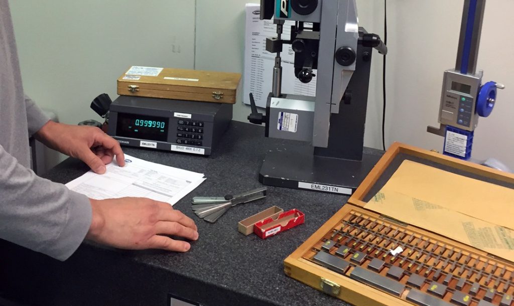 a man standing at a desk with some typewriters