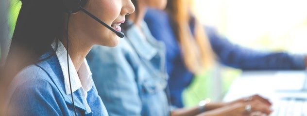 a woman wearing a headset and using a laptop