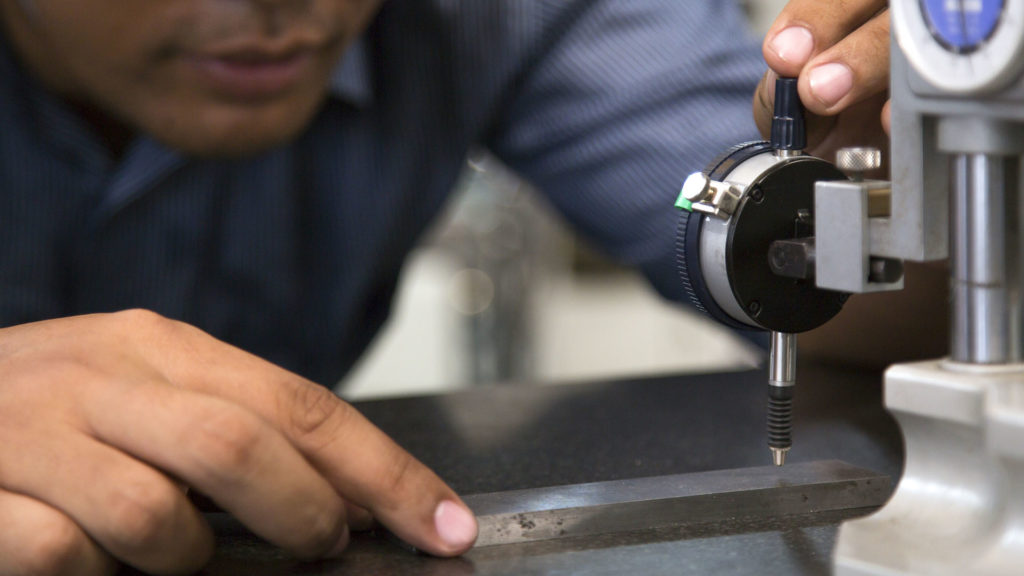 a man working with a machine on a table