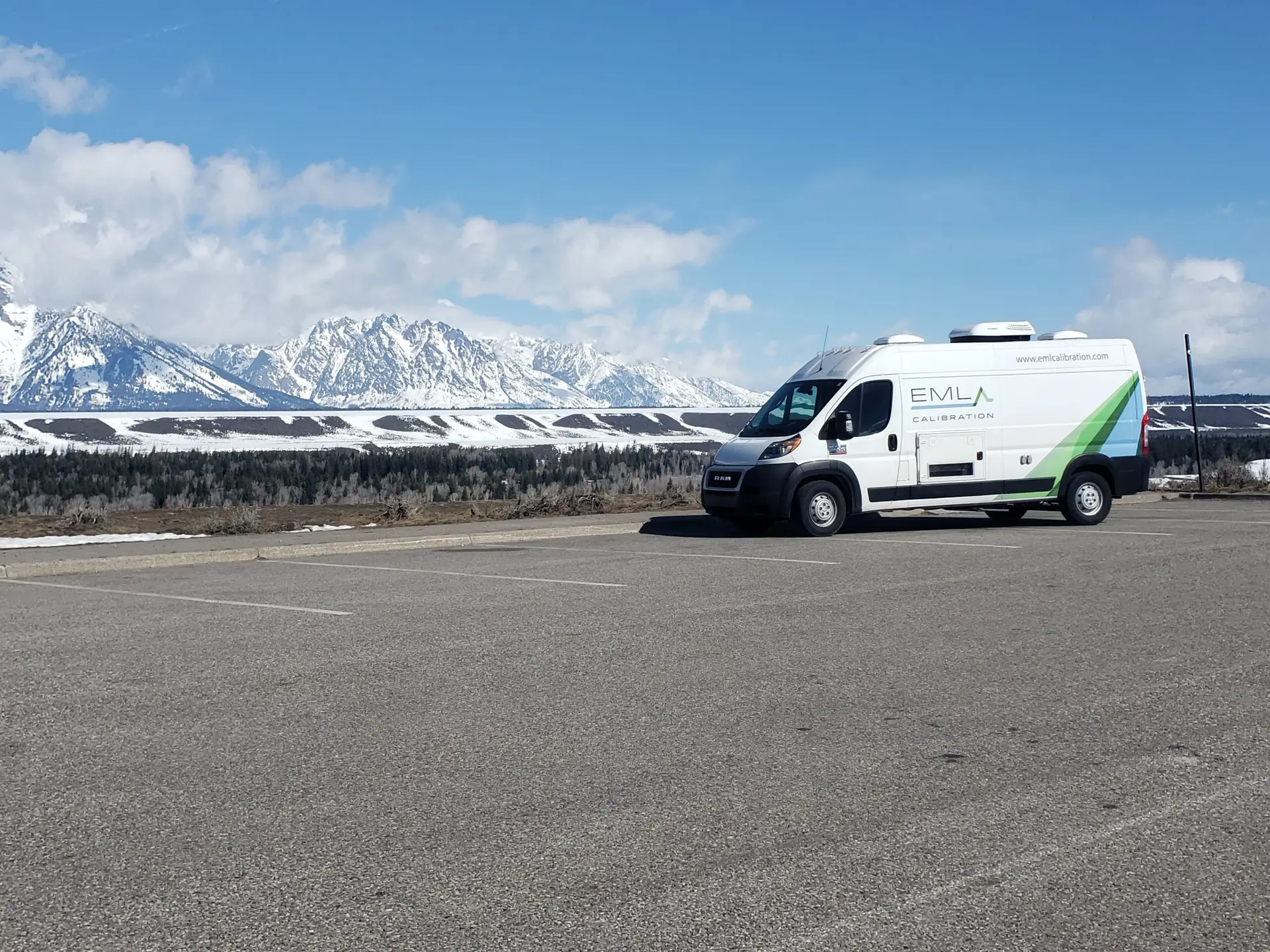 a van parked in a parking lot with mountains in the background